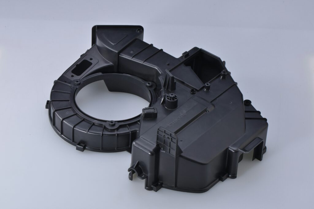 Precision injection-molded black plastic blower housing component showing molded ribs and bosses