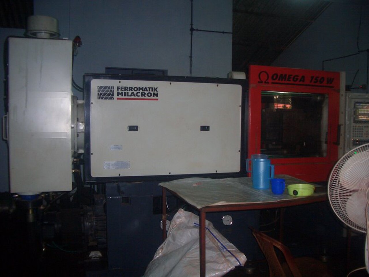 Ferromatik Milacron injection molding machine with molded parts on the table
